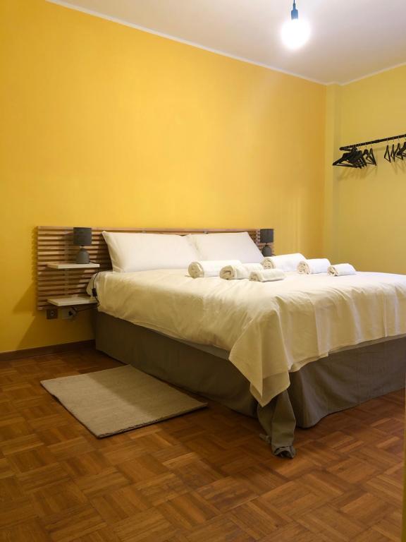 una camera da letto con un grande letto con pareti gialle di Trento House a Trento