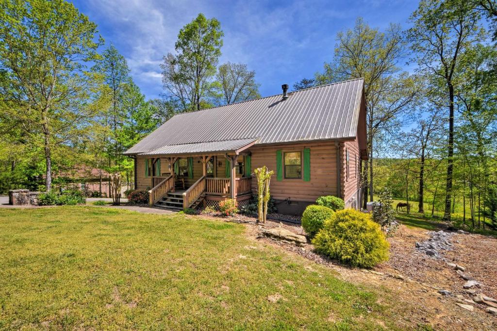 Una cabaña en el bosque con un gran patio. en Cozy Trenton Cabin with Spa about 15 Mi to Lookout Mtn!, en Trenton