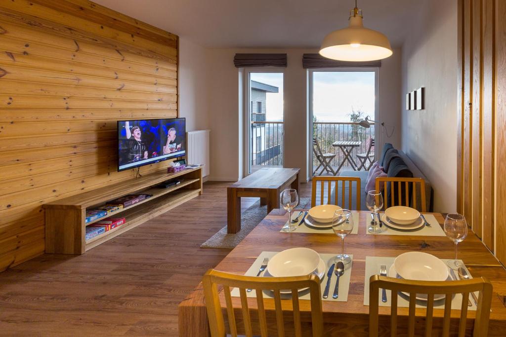 sala de estar con mesa de comedor y TV en Apartment Chamonix PRIMO, en Starý Smokovec