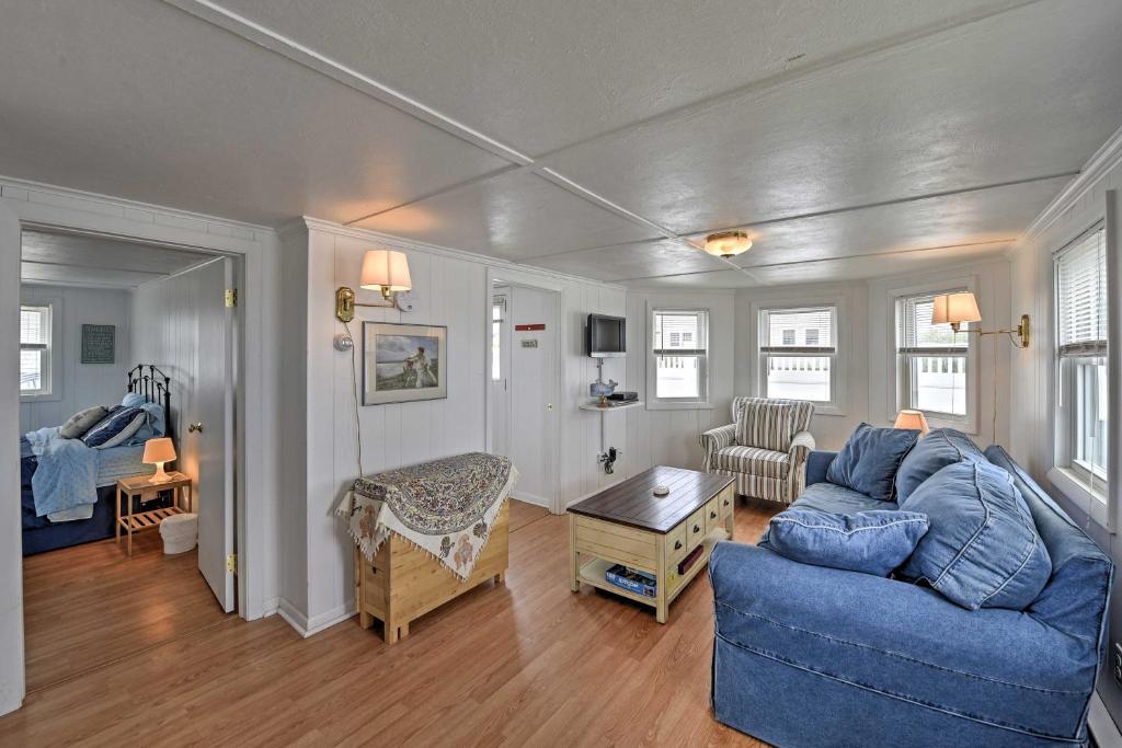 ein Wohnzimmer mit einem blauen Sofa und einem Tisch in der Unterkunft Peaceful Cottage with Grill - Steps to Matunuck Beach in South Kingstown
