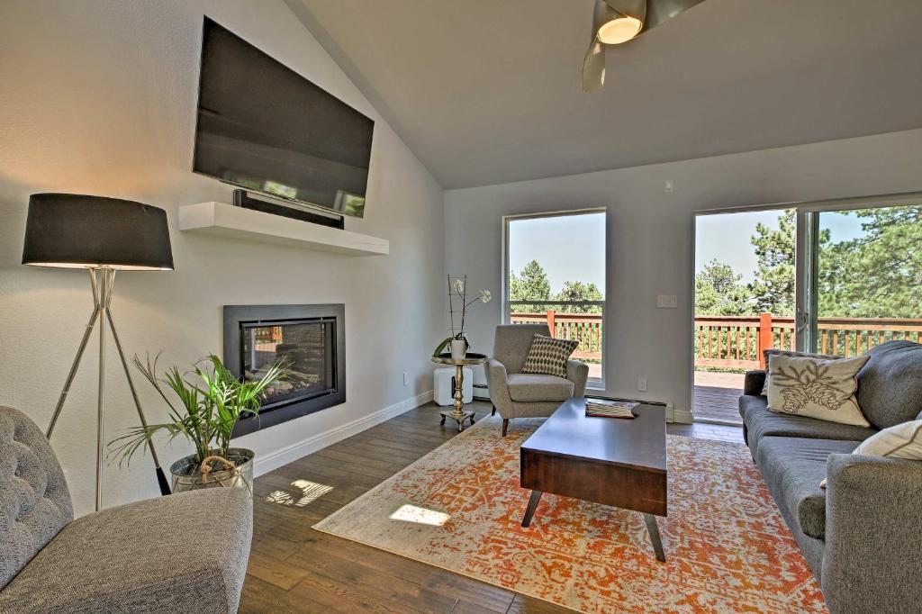 a living room with a couch and a table at Modern Morrison House with Deck and 2 Fireplaces! in Morrison