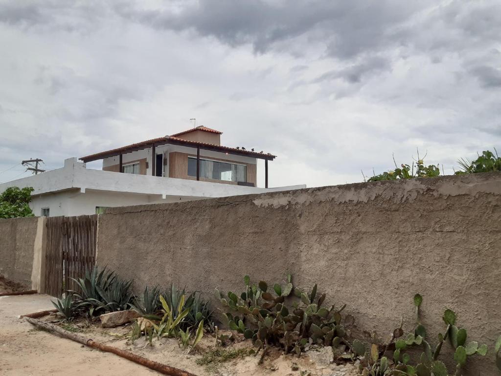 una casa en la parte superior de una pared de hormigón en Casa Sustentável em Figueira, Arraial do Cabo, en Arraial do Cabo