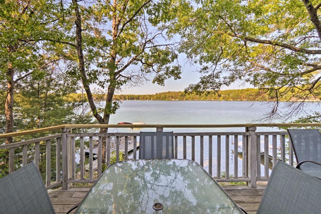 una mesa y sillas en una terraza con vistas al lago en Waterfront House with Dock and Deck on Little Bear Lake, en Johannesburg