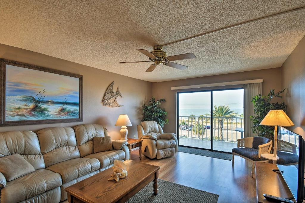 a living room with a couch and a ceiling fan at Coastal Condo with Balcony Walk to Madeira Beach! in St Pete Beach