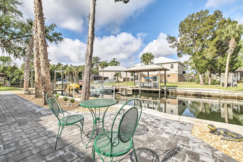 a patio with a table and chairs next to a body of water at Canalside Crystal River Home with Dock and Kayaks in Crystal River