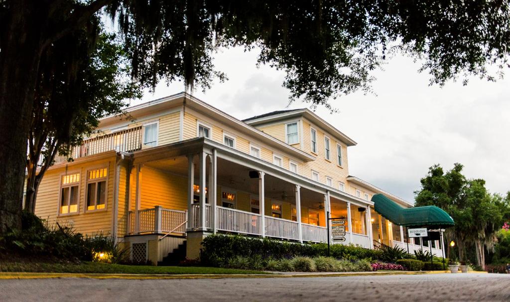 a large yellow building with a restaurant on a street at Lakeside Inn on Lake Dora in Mount Dora