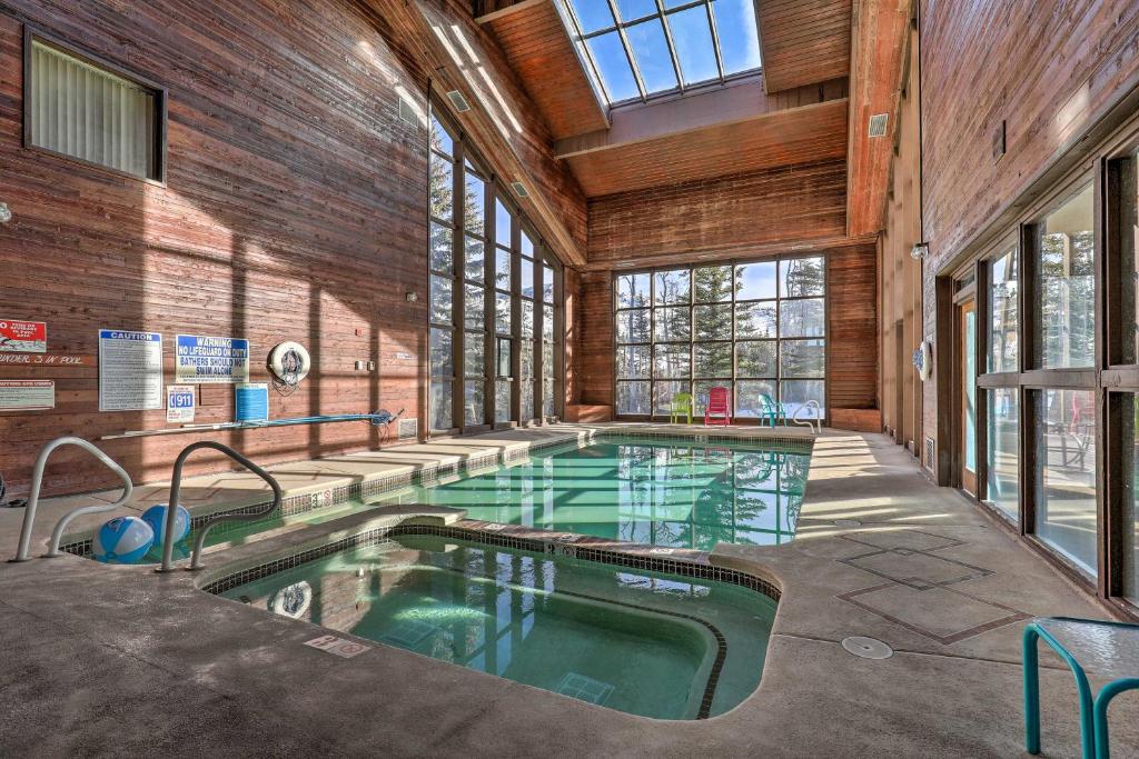 a swimming pool in a building with a large ceiling at Ski-InandSki-Out Brian Head Condo with Pool Access! in Brian Head