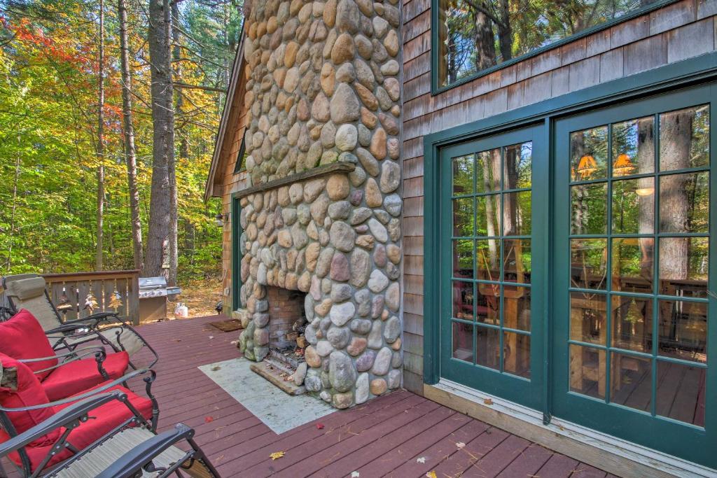 a stone house with a fireplace on a deck at Secluded Conway Home with Theater Room and Hot Tub! in Conway
