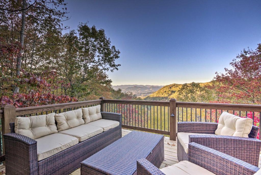 two wicker chairs and a couch on a deck with a view at Brevard Chalet with Stunning Blue Ridge Mtn Views! in Brevard