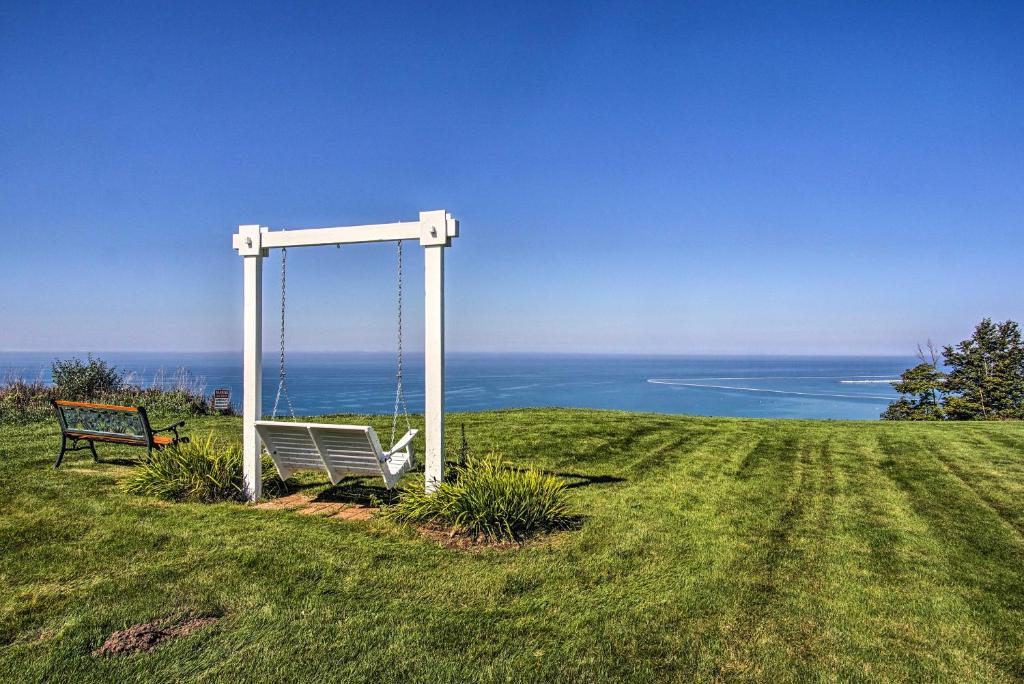 a bench sitting on top of a hill with the ocean at 7-Acre Coastal Michigan Home with Hot Tub and Sauna! in Ludington