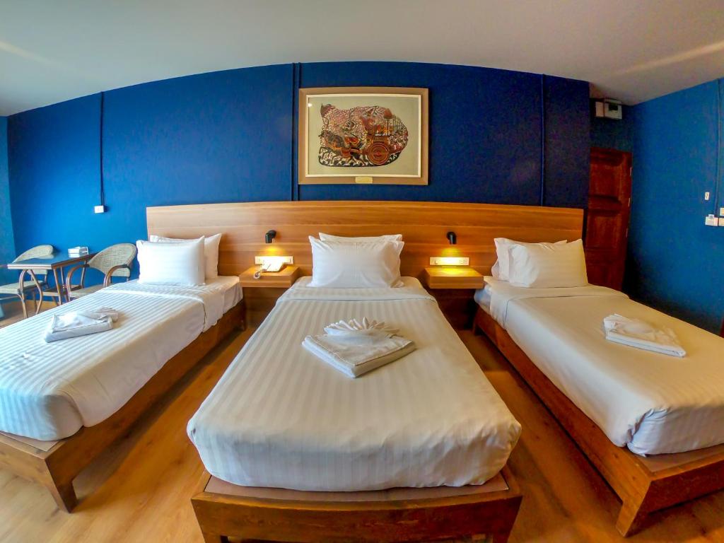 two beds in a room with blue walls at Siri Oriental Bangkok Hotel in Bangkok