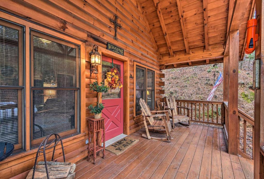 a cabin with a red door and chairs on a porch at Cherry Log Cabin 10 Min to EllijayandBlue Ridge! in Cherry Log