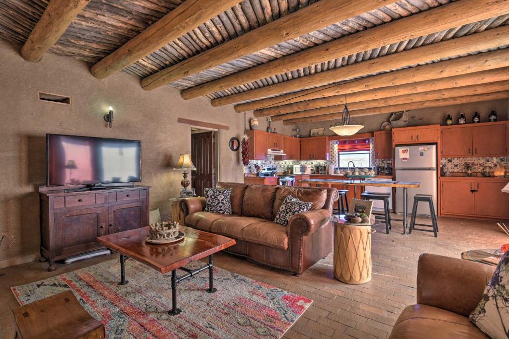 uma sala de estar com um sofá, uma televisão e uma cozinha em El Prado Adobe Home Courtyard with Mountain Views! em El Prado