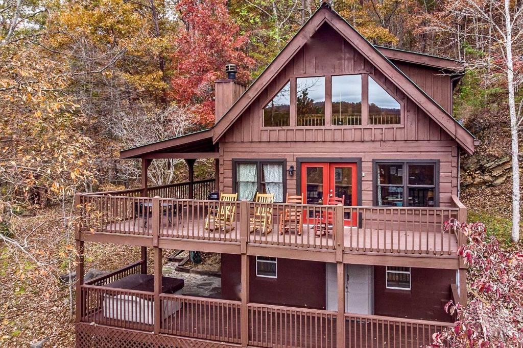 a large wooden house with a large deck at Pigeon Forge Scenic Solitude with Private Hot Tub! in Pigeon Forge