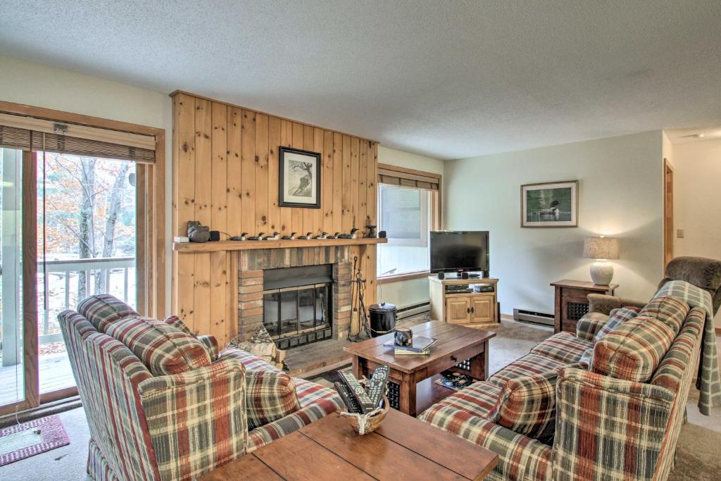 a living room with two couches and a fireplace at Riverfront Lincoln Condo with Pool Mins to Loon Mtn in Lincoln