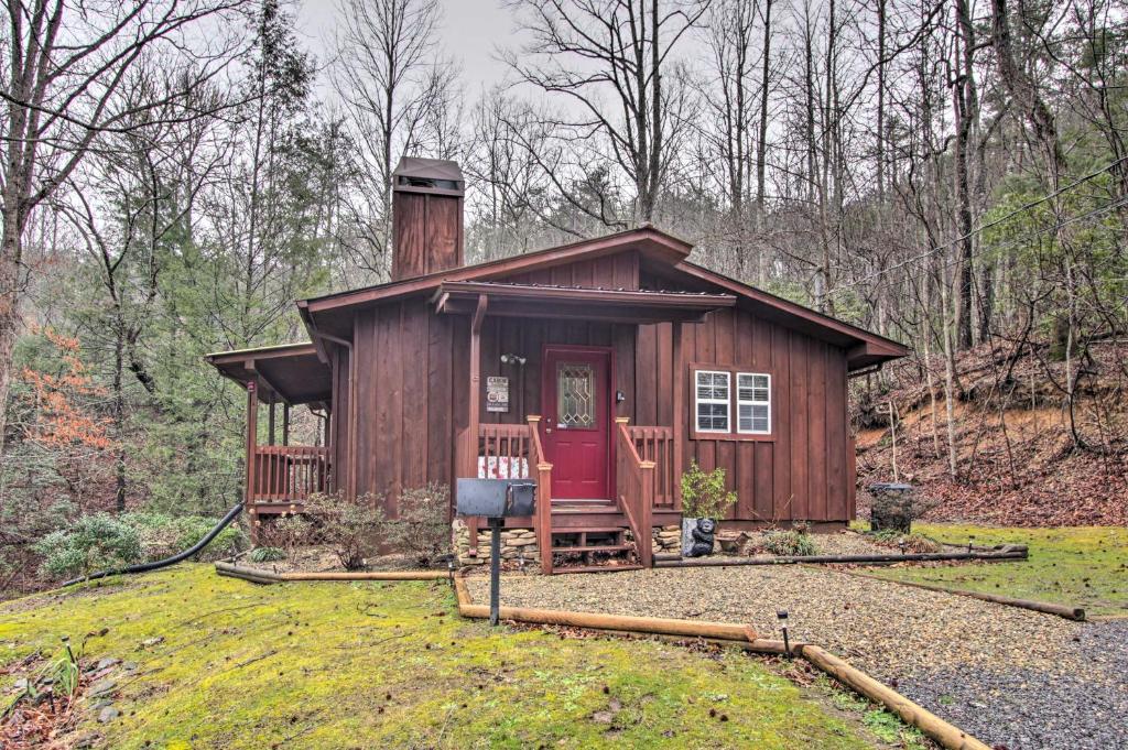 a small cabin in the middle of the woods at Private Gatlinburg Cabin Pet Friendly with Hot Tub! in Gatlinburg