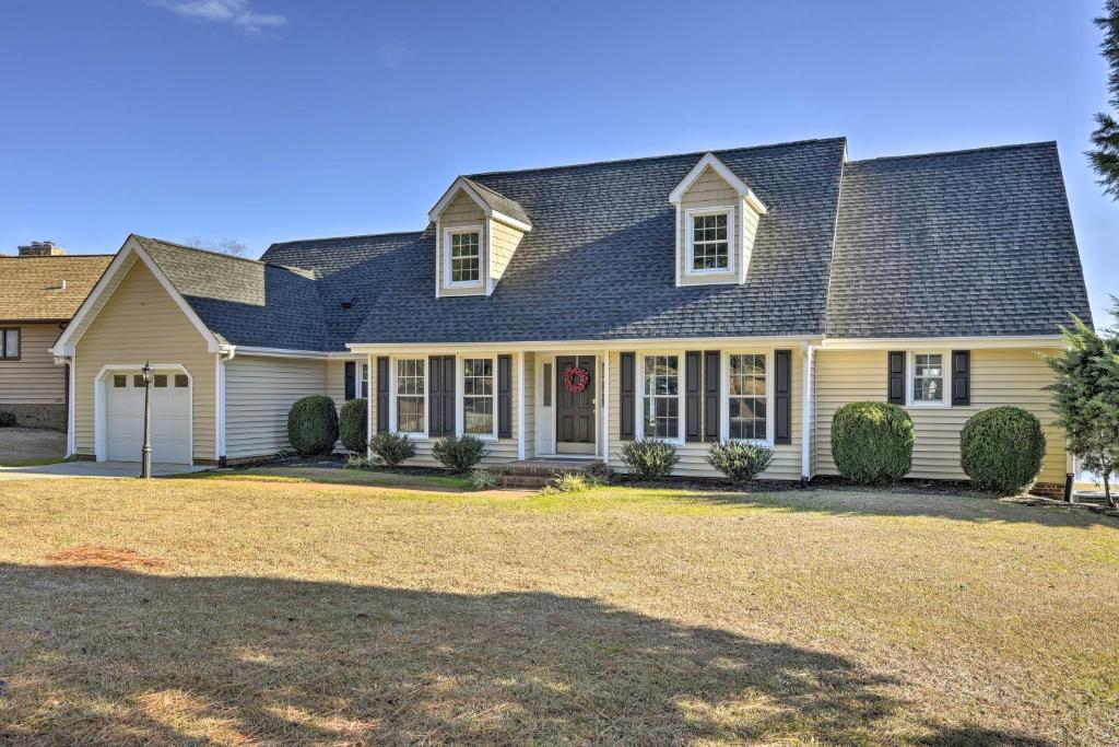 una casa grande con techo de gambrel en Carolina Lakes Family Home with Pool, Kayaks and Dock!, en Johnsonville