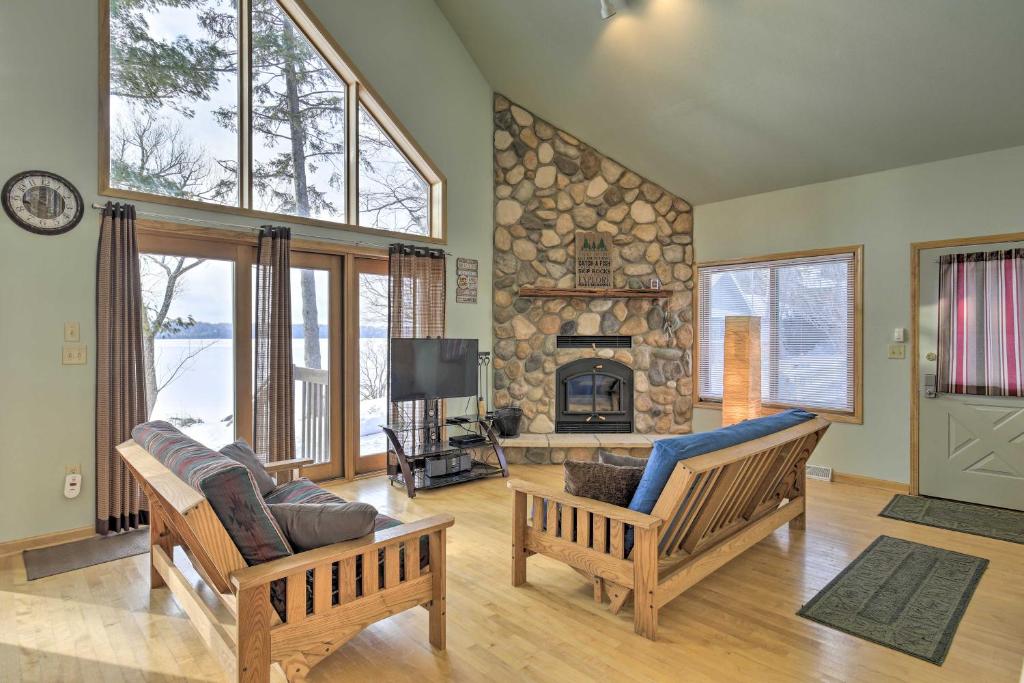 a living room with two chairs and a fireplace at Cozy Dam Lake Escape with Dock, Yard and Water Access! in Eagle River