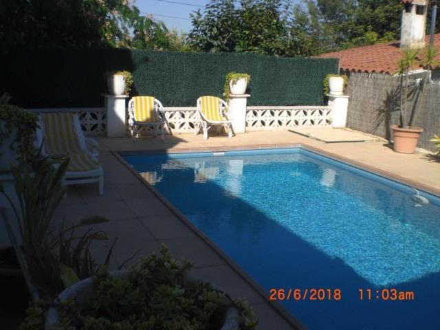 una piscina con 2 sillas junto a en Casa Rural Cal Josefina & Tomas, en La Riera