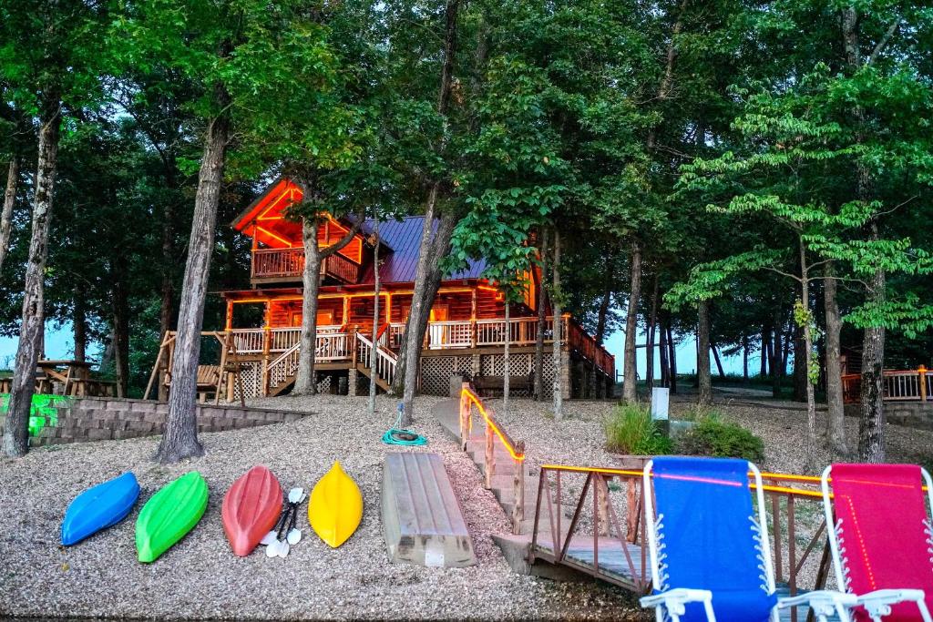 un parque infantil con una casa en el bosque en Remote Cabin on 30 Acres with Dock and Private Lake! en Macks Creek