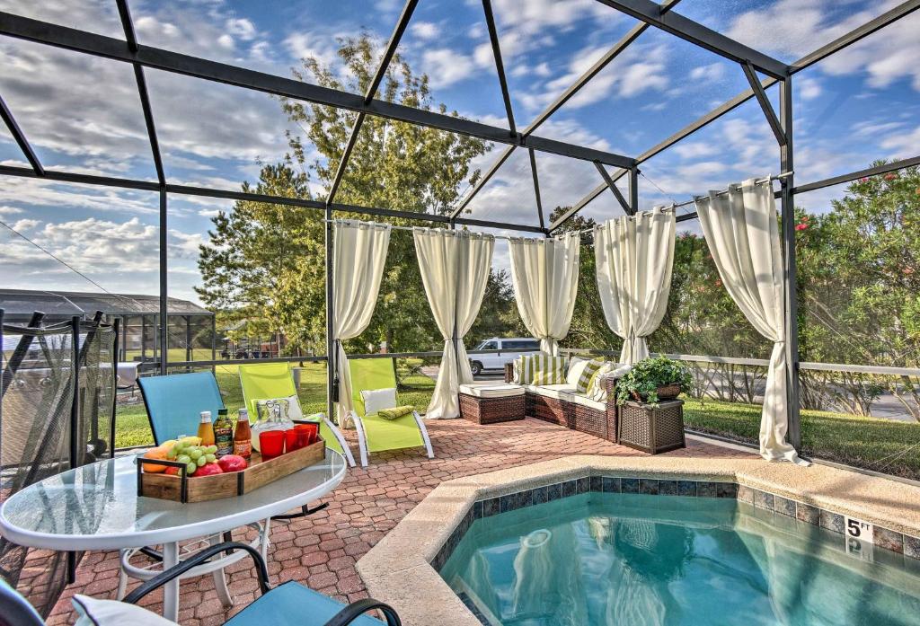 une terrasse avec une piscine, une table et des chaises dans l'établissement Upscale Kissimmee Vacation Rental with Private Pool!, à Kissimmee
