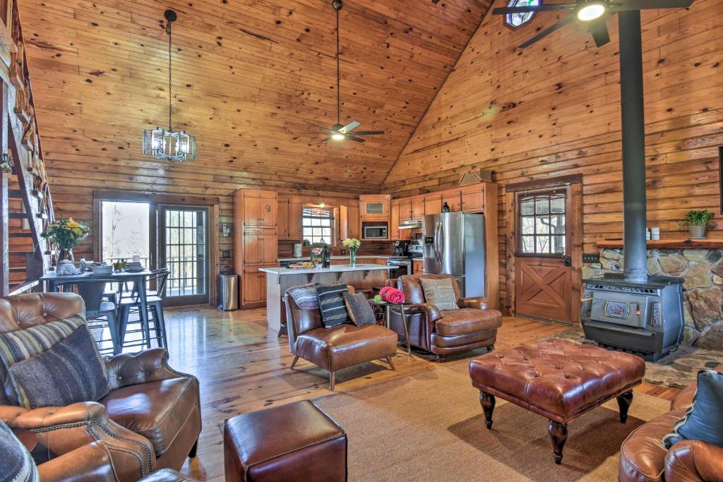 a living room with leather furniture and a stove at Luxury Log Cabin with 5 Private Acres and Hot Tub! in Pearcy