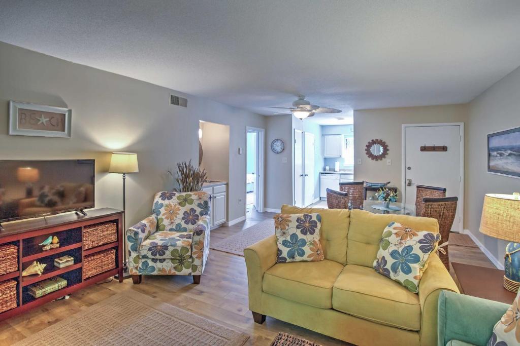 a living room with a couch and a tv at Amelia Island Condo with Onsite Pool and Beach Access! in Amelia Island