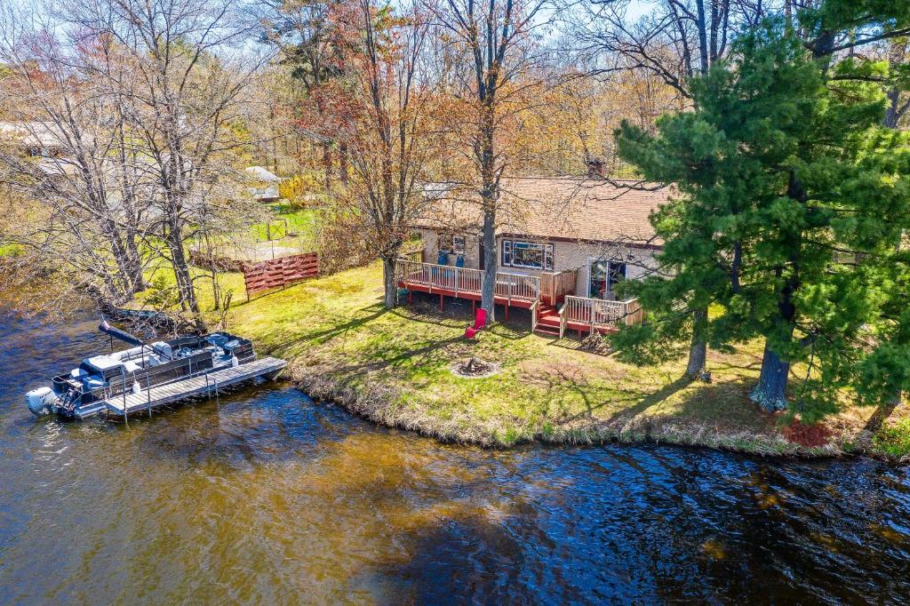 - une vue aérienne sur une maison avec un bateau dans l'eau dans l'établissement Remodeled Rice Lake Hideaway Home with Dock and Deck, à Rice Lake