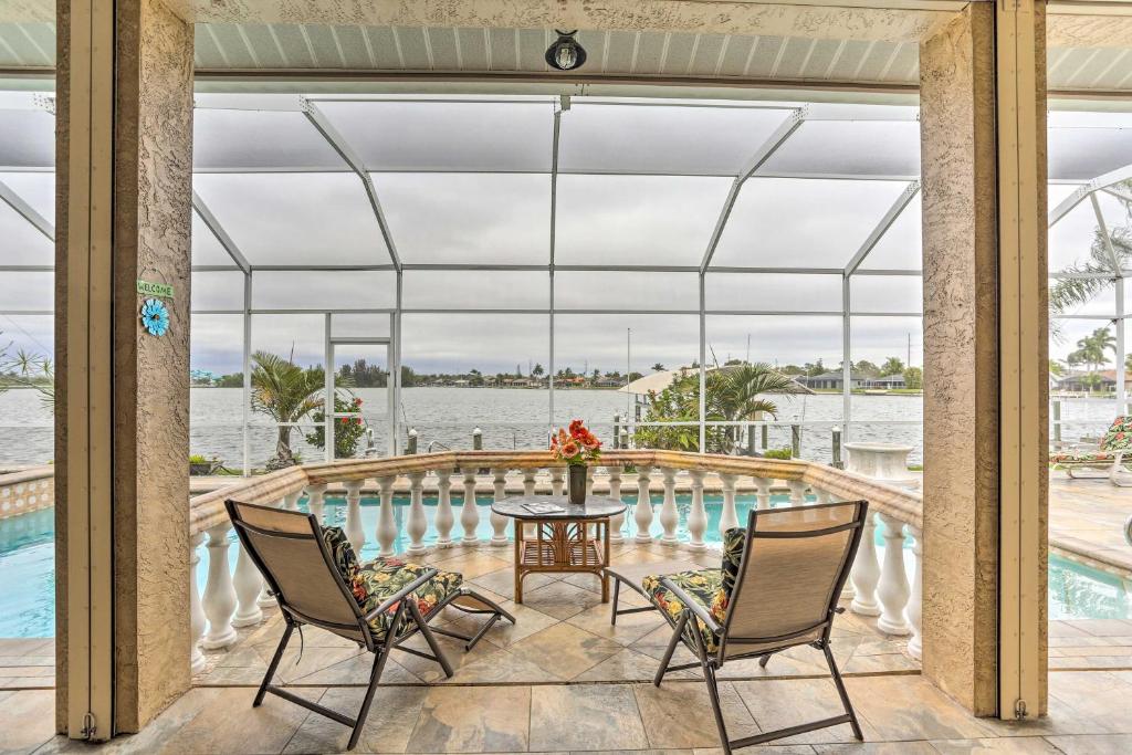 een afgeschermde veranda met een tafel en stoelen en een zwembad bij Lakefront Cape Coral Home with Private Pool and Dock! in Cape Coral