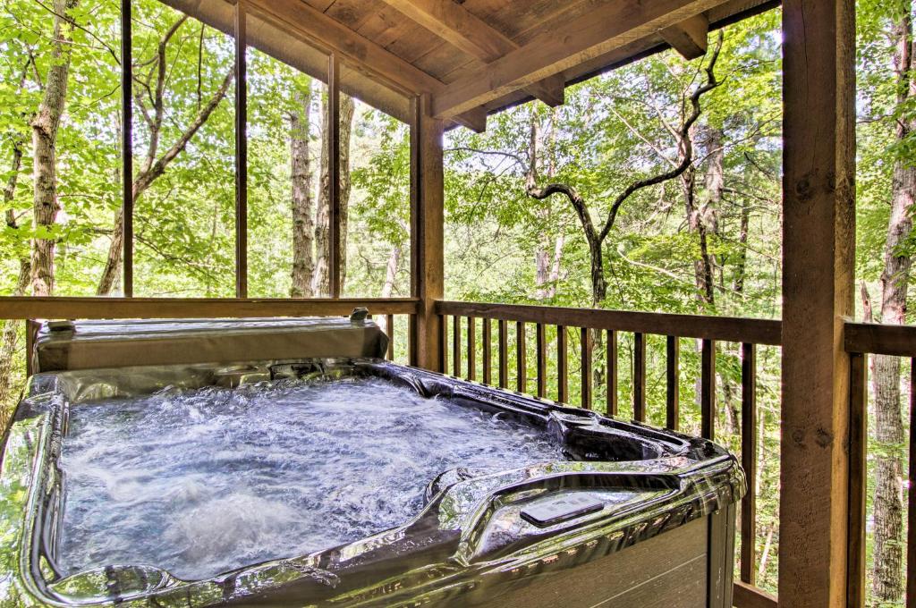 a hot tub on a screened in porch with trees at Secluded Forest Cabin, 4 Mi to Downtown Gatlinburg in Gatlinburg