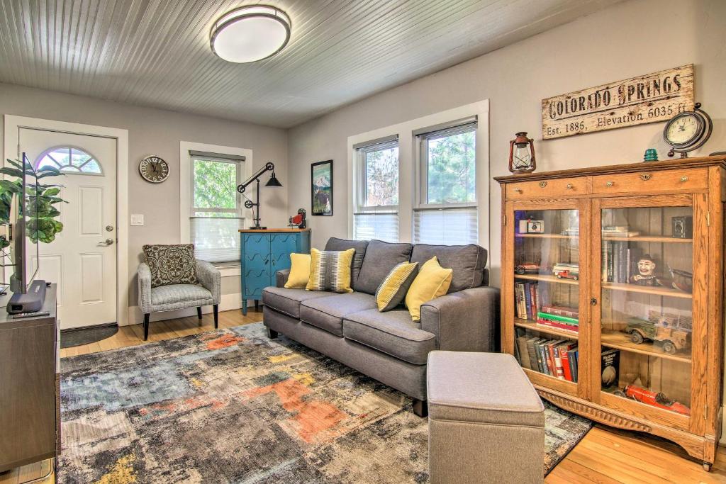 a living room with a couch and a book shelf at Colorado Springs Bungalow - Walk to Downtown! in Colorado Springs