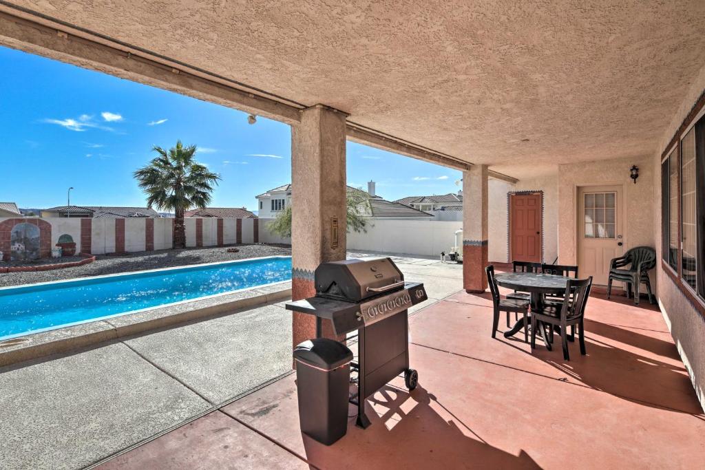 a patio with a grill and a swimming pool at Bullhead City Home Tesla Charger about 3 Mi to River in Bullhead City