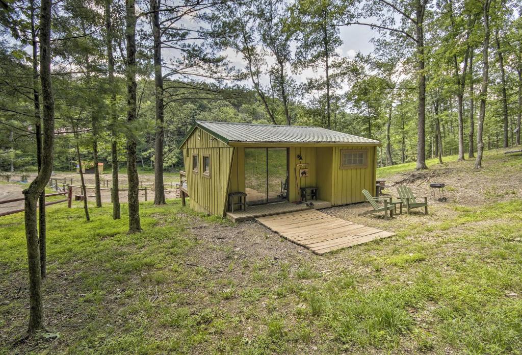 a small yellow shed in the middle of a forest at Lone Ranger Cabin with 50 Acres by Raystown Lake in Huntingdon