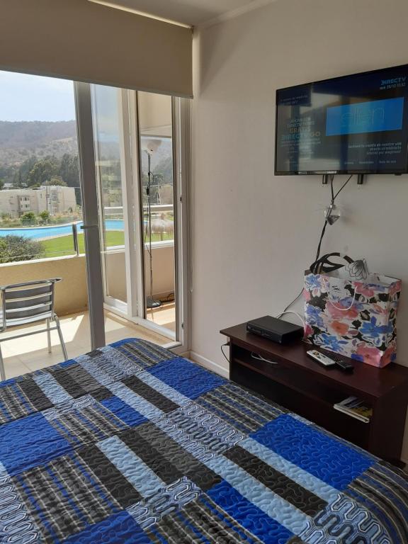 a bedroom with a bed and a flat screen tv at Lomas Papudo 4 in Papudo