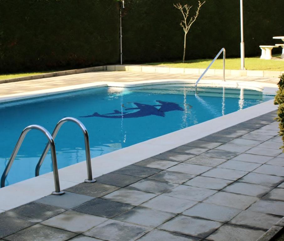 una piscina de agua azul en un patio en Skala en Noja