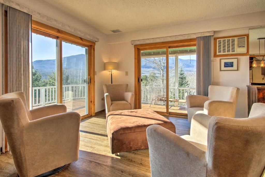 a bedroom with a bed and chairs and a balcony at Condo with Hot Tub, Mins to Story Land and Cranmore! in North Conway