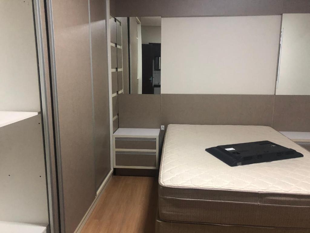 ein kleines Zimmer mit einem Bett und einem Spiegel in der Unterkunft Casa condomínio lagoa cortada in Balneário Gaivotas