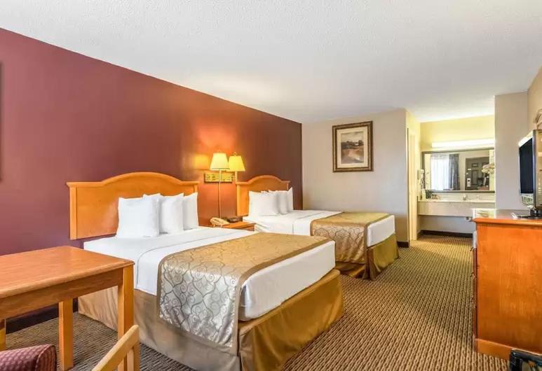 The Parkwood Inn & Suites في ماونتن فيو: غرفة فندقية بسريرين وطاولة