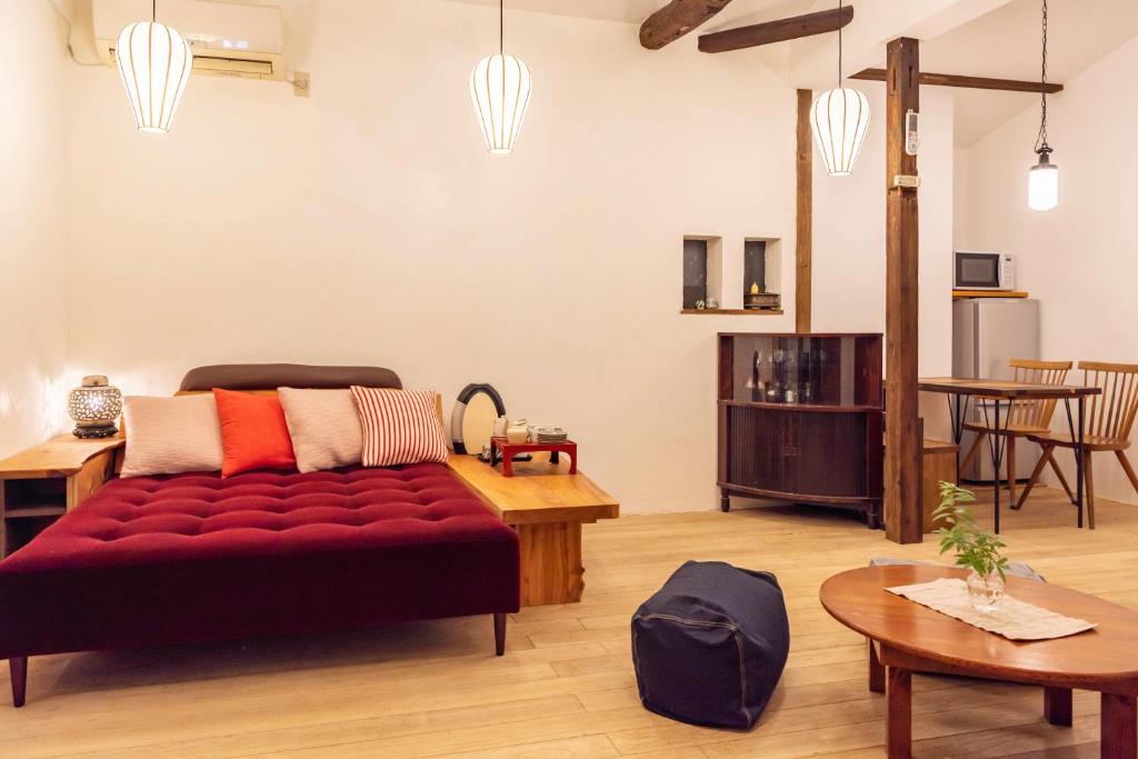 ein Wohnzimmer mit einem roten Sofa und einem Tisch in der Unterkunft back alley residence Hibi in Osaka