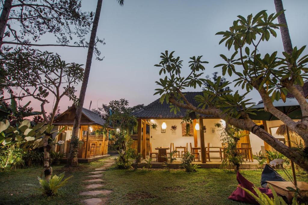 a house in the middle of a garden with trees at Abimana Ubud in Ubud