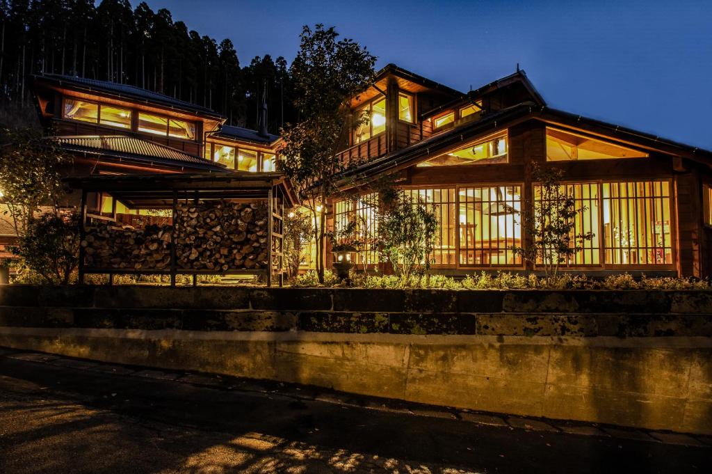 drewniany dom z oknami w nocy w obiekcie inn NOSHIYU w mieście Minamioguni