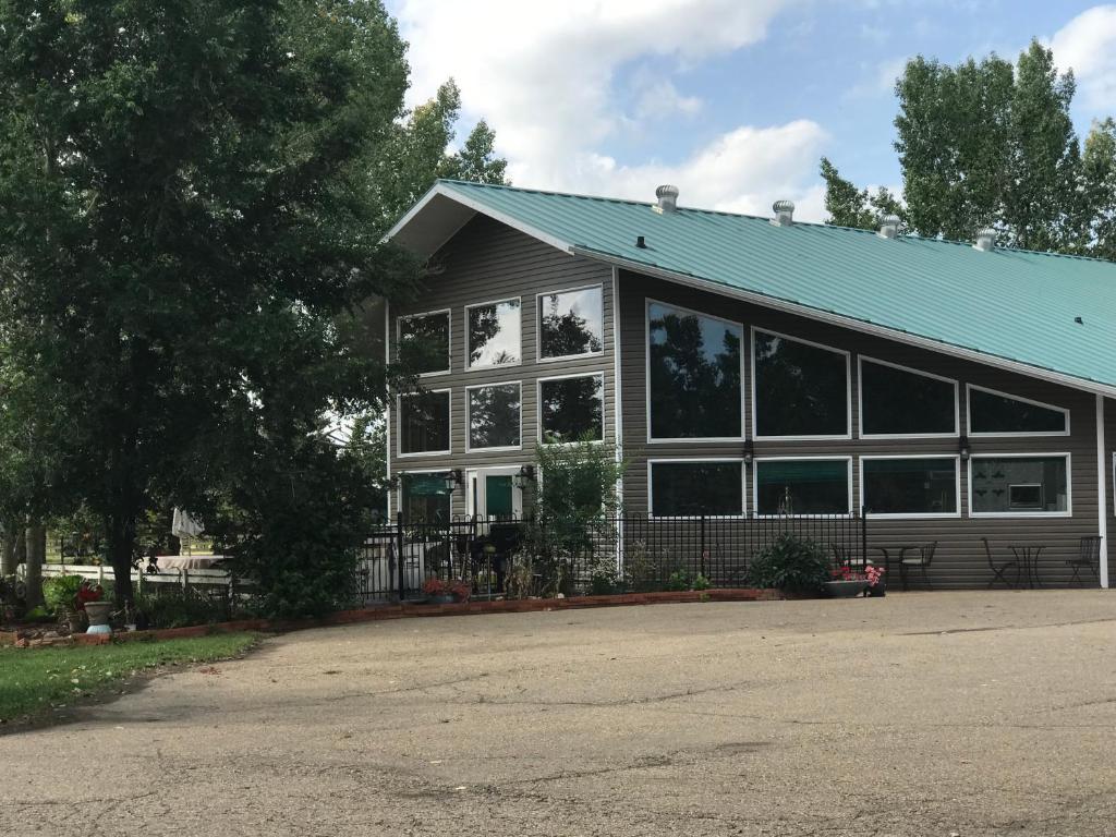 a house with a blue roof and a lot of windows at Rolling Hills Country Resort Bed and Breakfast in Three Hills