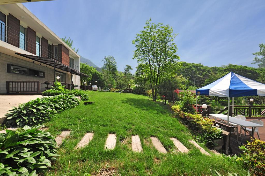 a yard with a tent and a table and chairs at Solnanggu Pension in Gapyeong