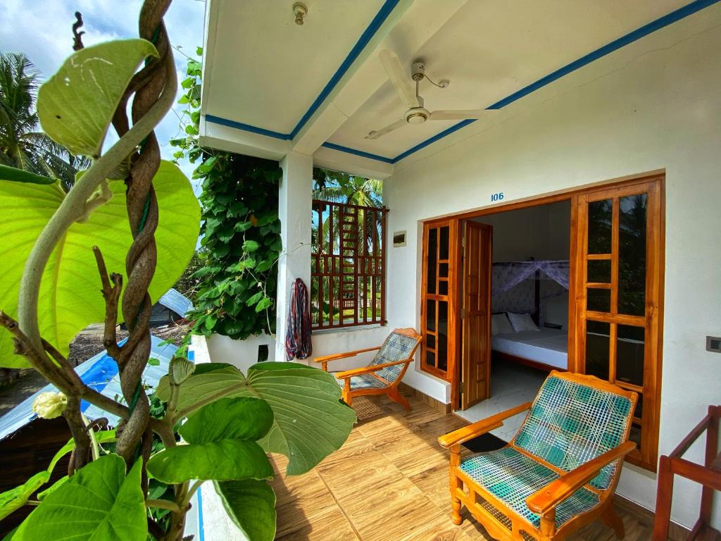 a room with a porch with a chair and a bed at Aqua Blue in Arugam Bay