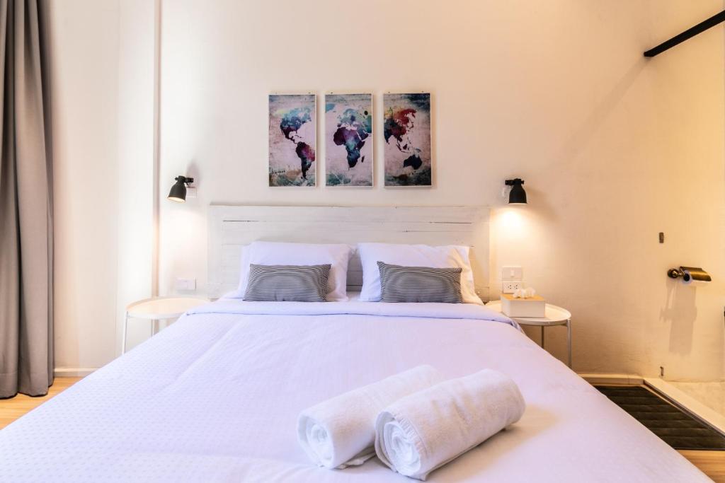 曼谷的住宿－UHU Bangkok，卧室配有一张白色大床和两条毛巾