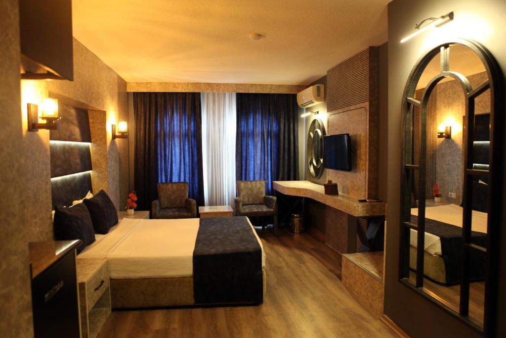 een hotelkamer met een bed en een spiegel bij Aktas Hotel in Mersin