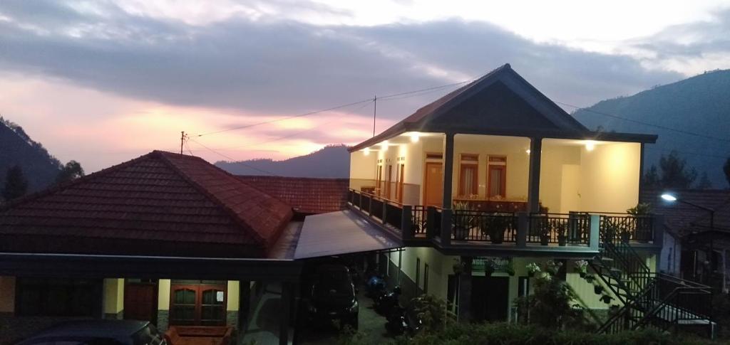 a house with a balcony on top of it at Homestay Anggun Bromo in Bromo