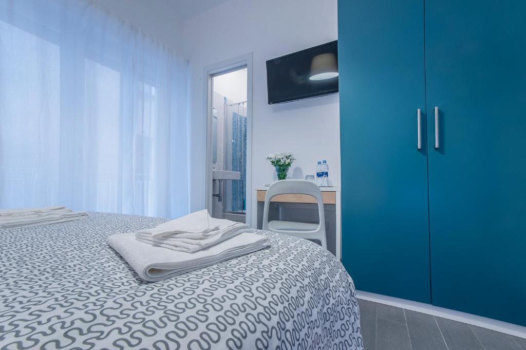 een blauwe slaapkamer met een bed en een stoel bij B&B Sempione in Cosenza