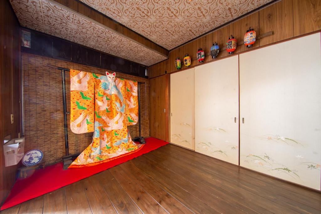 une chambre avec une peinture d'une femme sur le mur dans l'établissement Bettei Rin 別邸 凛, à Kyoto
