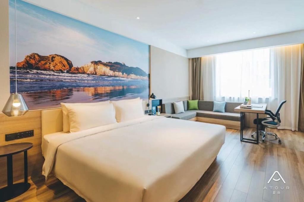 南京市にあるAtour Hotel Nanjing Banqiaoの大きなベッドとデスクが備わるホテルルームです。